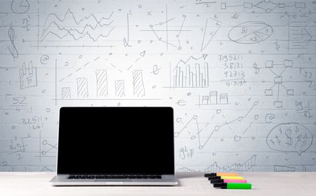 professional-laptop-blank-screen-sitting-white-478024678 A professional laptop with blank screen sitting on a white office desk in front of wall full of pie charts, calculations and graphs concept