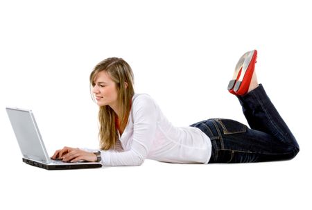 Beautiful smiley woman using a laptop computer on the floor - isolated over a white background