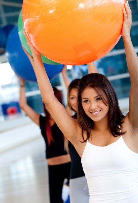 women in aerobics class at the gym with pilates ball