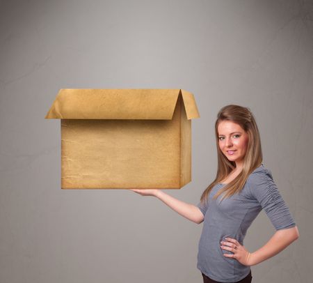 Beautiful young woman holding an empty cardboard box