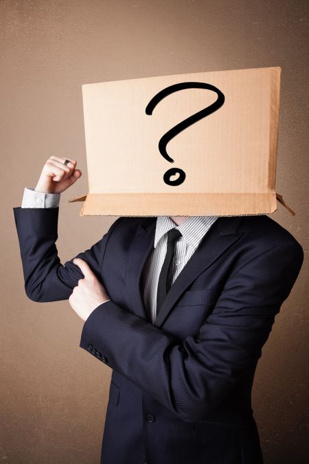 Businessman standing and gesturing with a cardboard box on his head with question mark