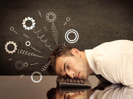 Falling apart illustration concept with cranks, cog wheels springing from a fed up and tired businessman's head resting on laptop keyboard