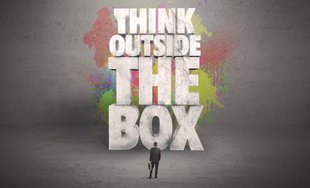 colorful-wall-illustrated-quote-saying-think-481511416 Colorful wall with illustrated quote saying think outside the box for a small businessman standing in grey urban space concept