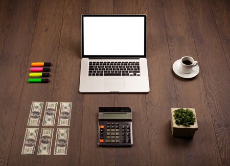 Business wooden desk with office supplies and modern laptop white background