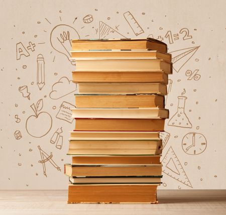 A pile of books on table with school hand drawn doodle sketches and symbols