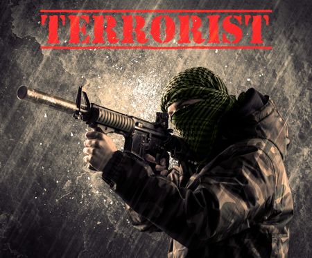 Portrait of dangerous masked and armed man with terrorist sign on grungy background