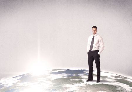 A young elegant office worker standing on top of a drawn world globe while celebrating his successful career concept.