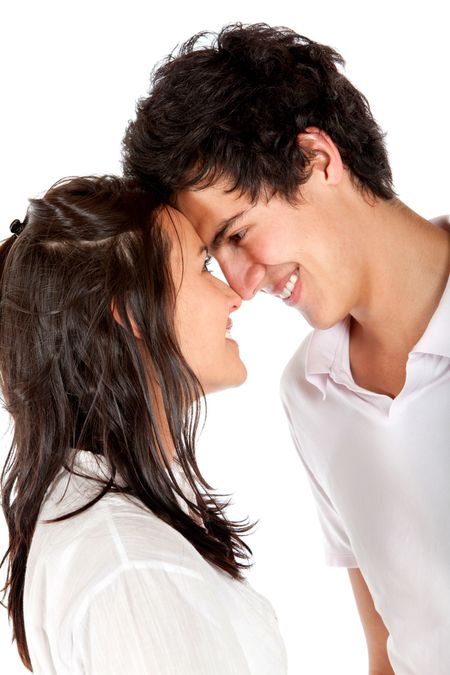 Beautiful couple portrait smiling and facing each other isolated over white