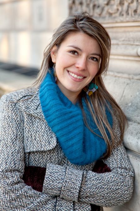 young woman wearing winter clothes and smiling outdoors