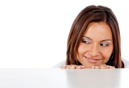 casual woman smiling and leaning on a table isolated over a white background