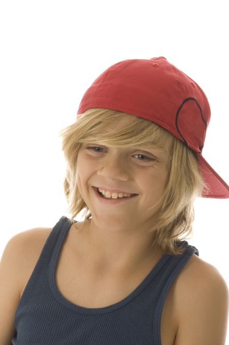 Grinning Caucasian boy of ten with long blond hair wearing red baseball cap (backwards) and blue tanktop