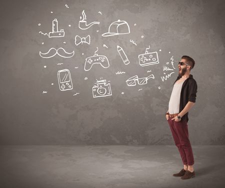 A funny hipster person in casual urban clothing shouting drawn everyday items like camera, tie or pen on city wall concept