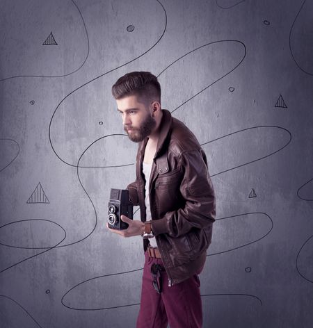 A modern young male in casual fashion style clothing making funny facial expressions while standing