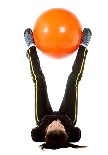 gym woman doing pilates exercises on an orange ball isolated over white