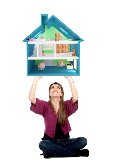 Beautiful girl lifting a piggyhouse isolated over a white background