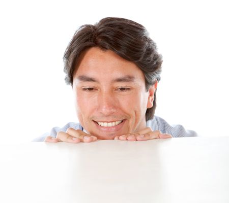 casual man smiling and leaning on a table isolated over a white background