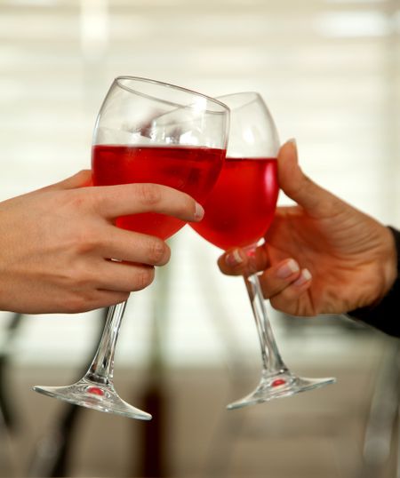 Hands holding glasses of wine and toasting