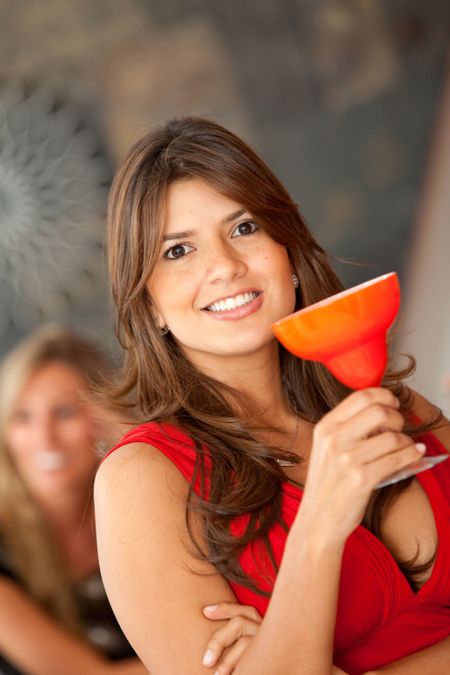 Beautiful woman holding a cocktail drink and smiling