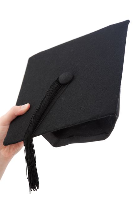 Hand holding a mortarboard isolated over a white background