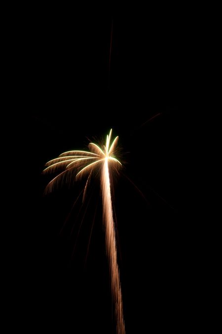 Small white-hot burst of fireworks with rocket trail