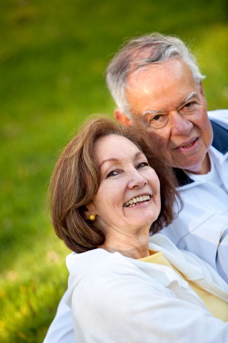 Happy loving couple sitting outdoors and smiling