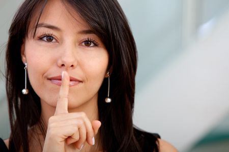 Business woman making a silence sign with her hand