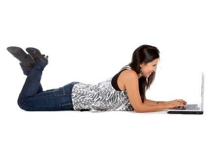 Woman lying on the floor working on a laptop - isolated over white