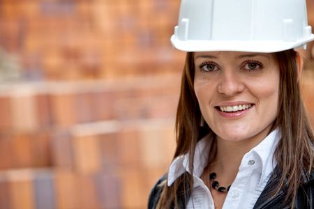 Beautiful female engineer wearing a helmet and smiling