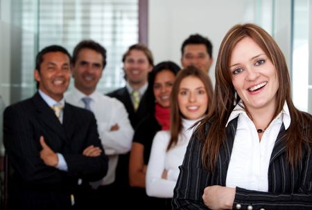 Business woman smiling at the office with her team