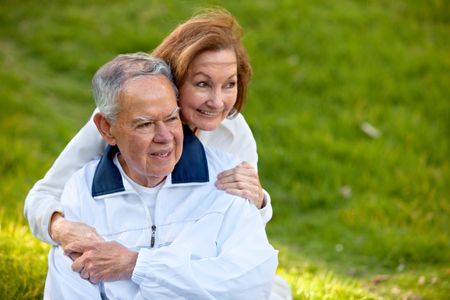 Loving couple outdoors smiling enjoying their retirement