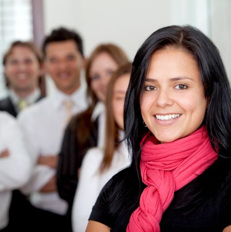 Beautiful business woman with her teamwork behind indoors