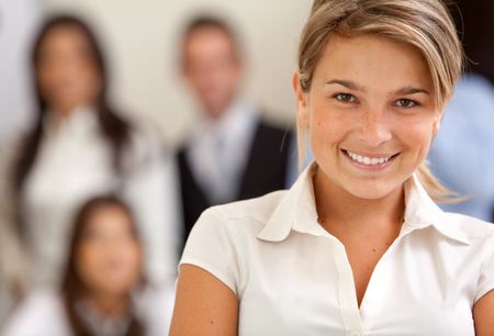 Business woman at the office with a group behind