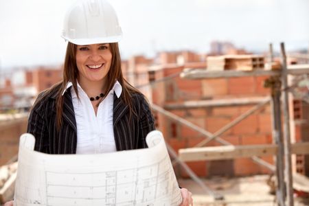 Elegant engineer holding a model in a construction