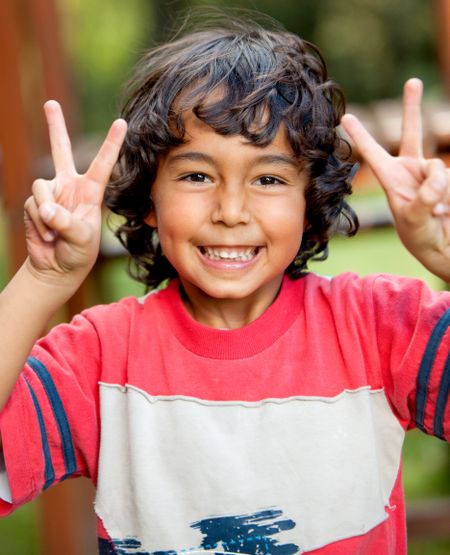 Little latinamerican boy playing outdoors and smiling