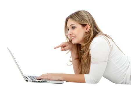 Casual girl pointing something on a laptop isolated over a white background