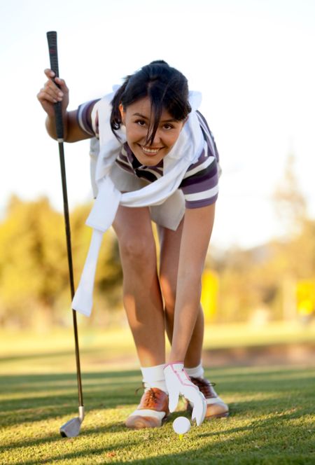 Woman placing a golf ball on the course