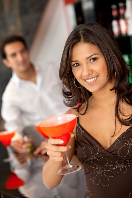 Woman at a bar having a cocktail drink