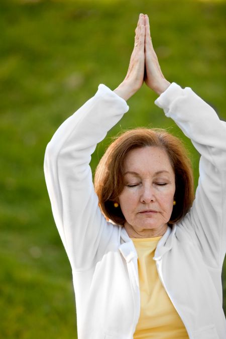 Fit woman practicing yoga at the park