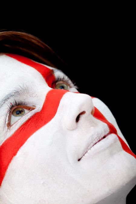 Portrait of a woman with the english flag paited on her face - over a black background