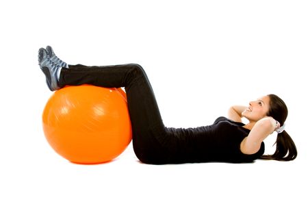 Woman doing exercises for her abs with a pilates ball - isolated over white