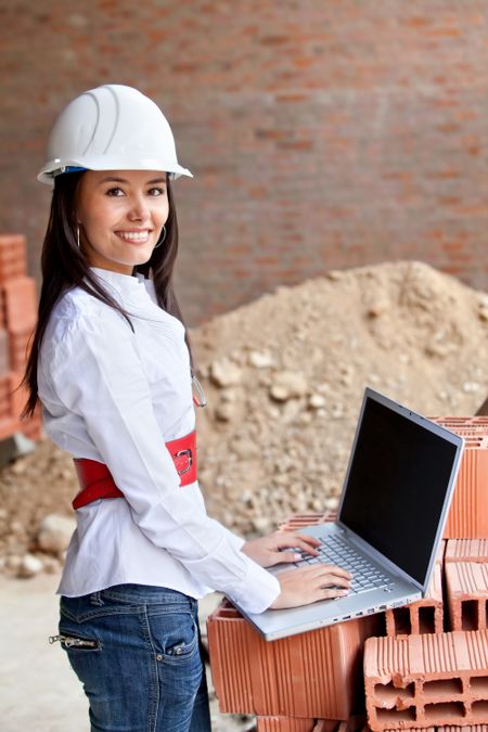 Female engineer with a computer at a construction site