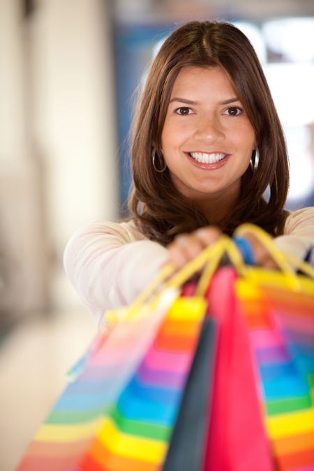 happy woman smiling with shopping bags in a mall