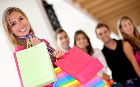 Group of friends shopping in a mall with some bags