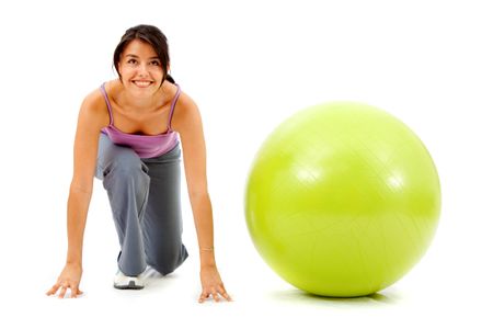 fitness woman with a pilates ball - ready to race isolated over a white background