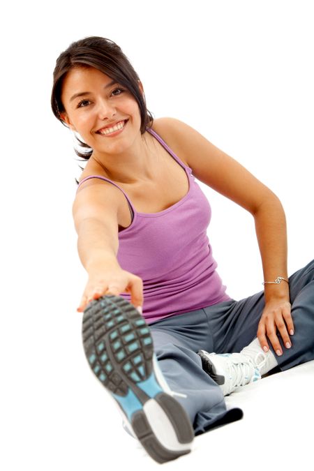 Woman doing stretching exercises on the floor isolated over a white background