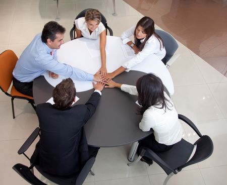 businessteam in an office with hands together for teamwork