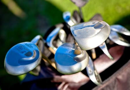 abstract golf clubs with green grass in the background