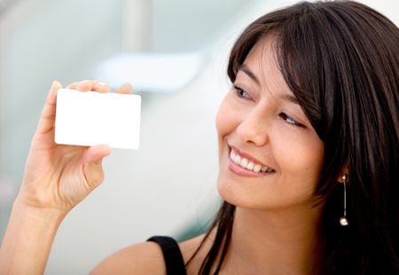 Woman displaying a business card and smiling