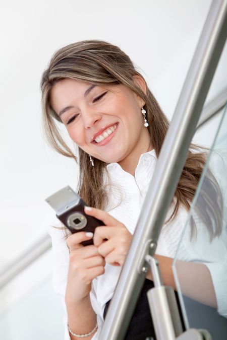 Business woman texting on her cell and smiling