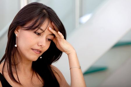Concerned business woman touching her head at the office